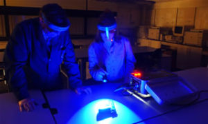 Students inspect a weapon under black light in their Criminalstics lab
