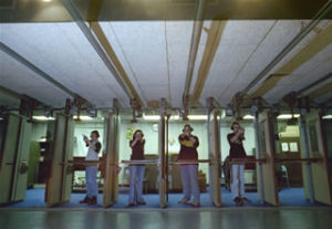 Four students practice their shooting stance while in our indoor firing range