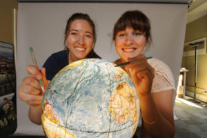 Two students map their future on a globe.