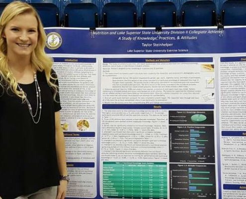 Taylor Steinhelper standing in front of her senior research poster