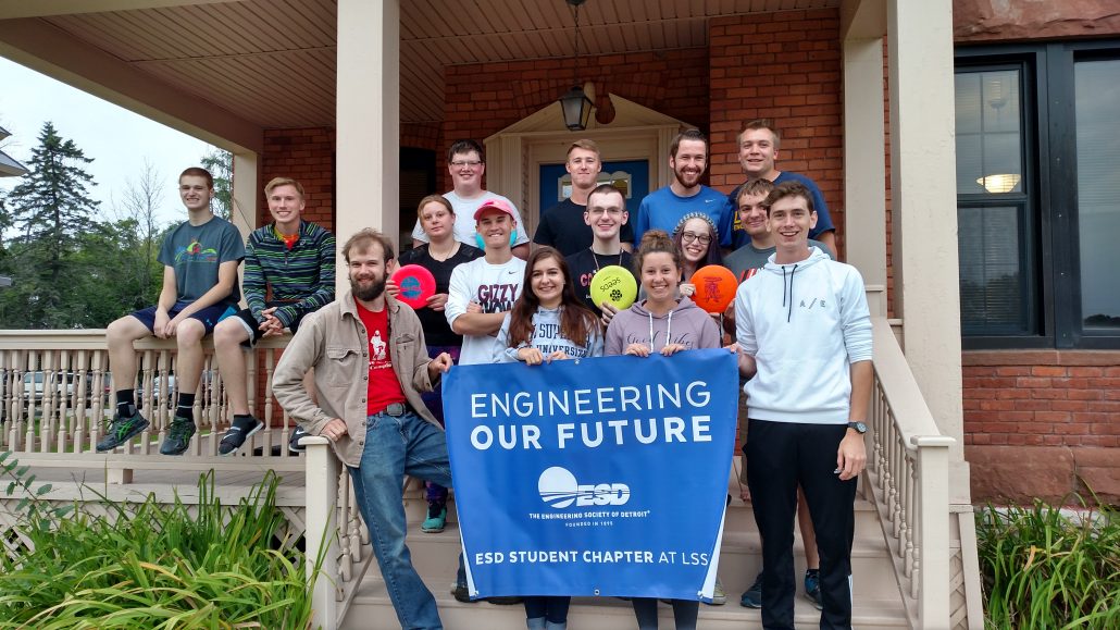 Group of engineering house students standing in front of their learning community house at Chippewa house