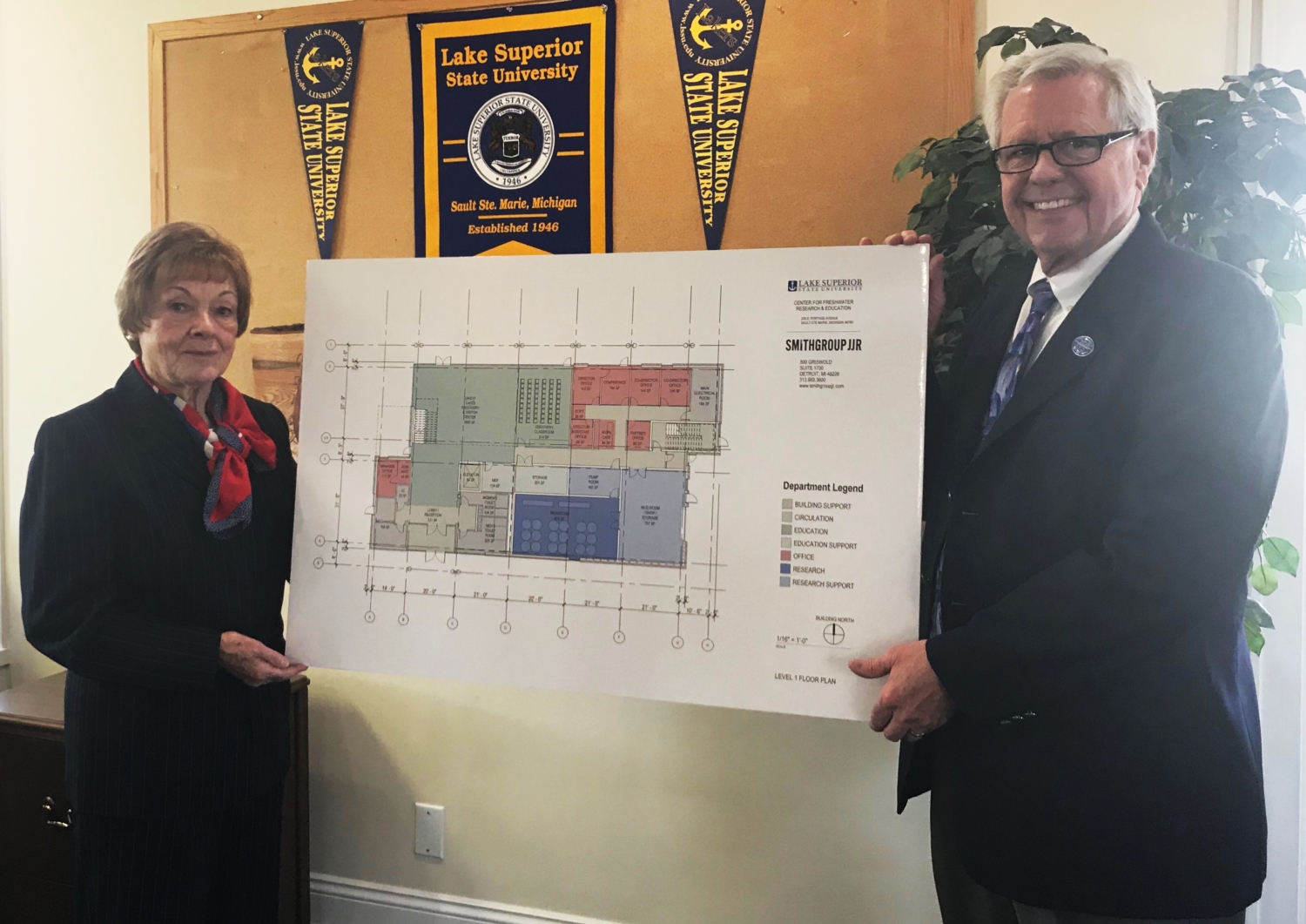 Drs. Connie Baker and Peter Mitchell posing with conceptual floor plan of the Center for Freshwater Research and Education