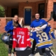 LSSU Foundation staff members pose with items available for auction during the online and live auctions as part of the Lake State Classic.
