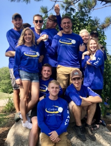 Residence Life Staff resident advisors and resident success coaches standing on a rock near the lookout bridge point on campus