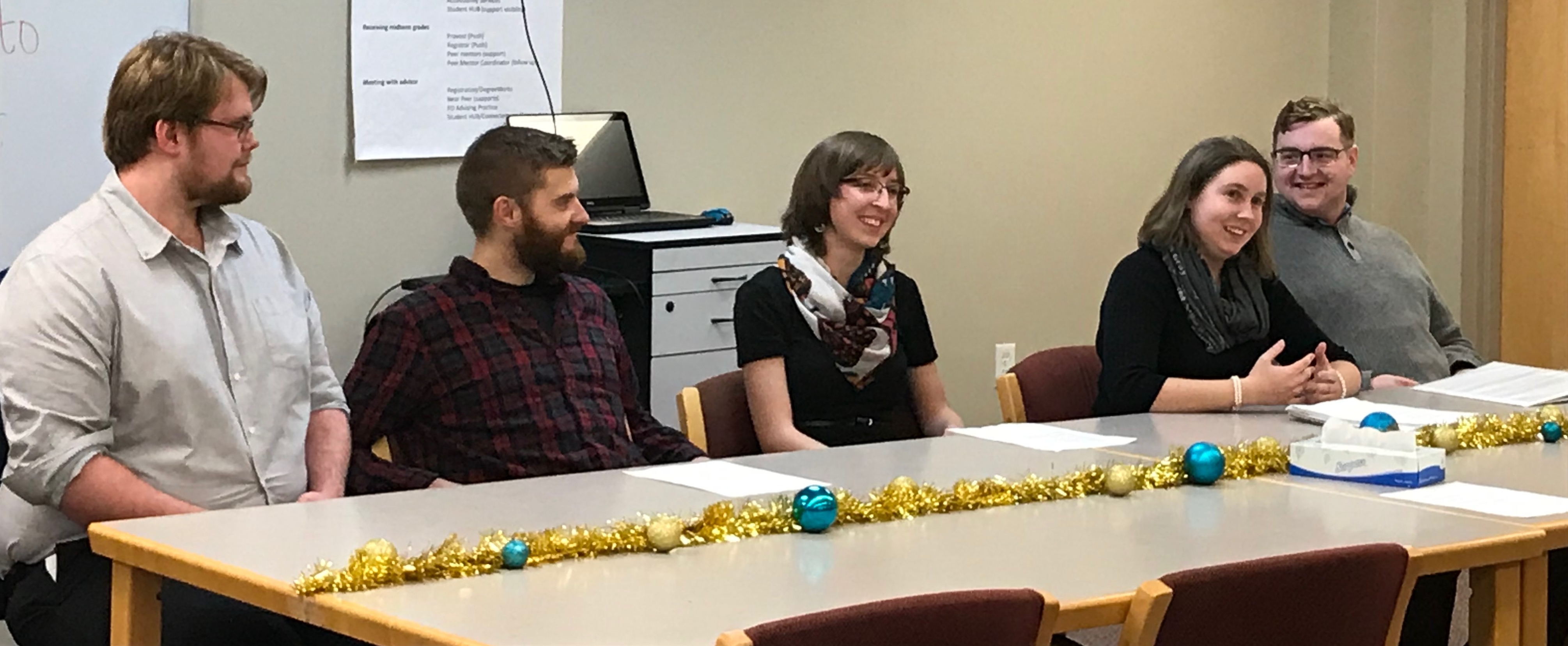 Five students sit at a table.