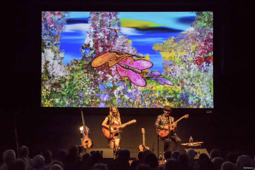 Julie Patchouli and Bruce Hecksel on stage playing guitar