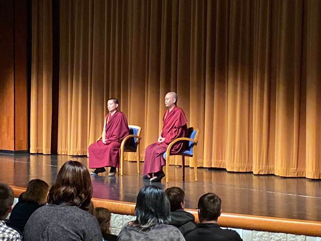 Bhara Tulku and Geshe Tenzin during a lecture, on stage.