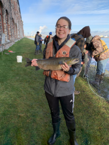 Sarah Norris is holding a male Atlantic Salmon collected for broodstock