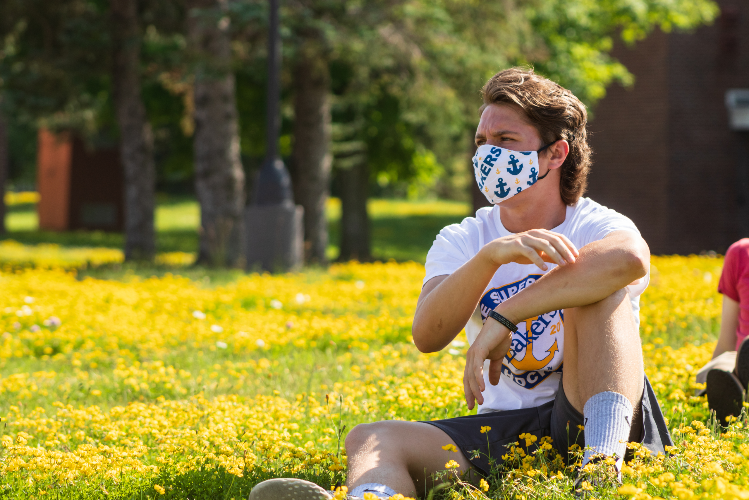 student in grass wearing mask