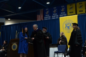 Interim President Dr. Lynn G. Gillette shakes hands with a new graduate.