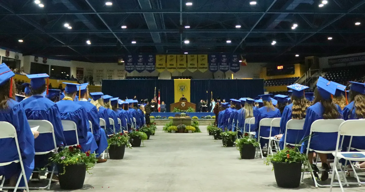 Photo of LSSU commencement stage, speaker on podium addressing students, showcasing commencement event.