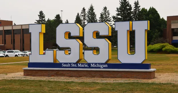 Large 'LSSU' letters on a brick platform seen on LSSU campus