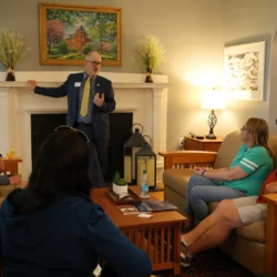 University President Dr. David Travis speaks with small group of parents and supporters inside his house on campus.