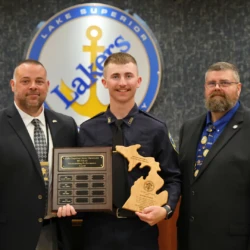 Standout graduate seen holding awards alongside instructors