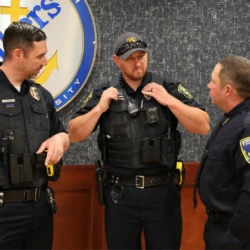 Graduate stands next to employees of the department they're now working for