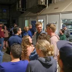 LSSU community conversing and smiling inside the Fish Hatchery immediately following the completion of LSSU's release.