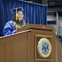 Student Speaker at commencement podium addressing fellow graduates.