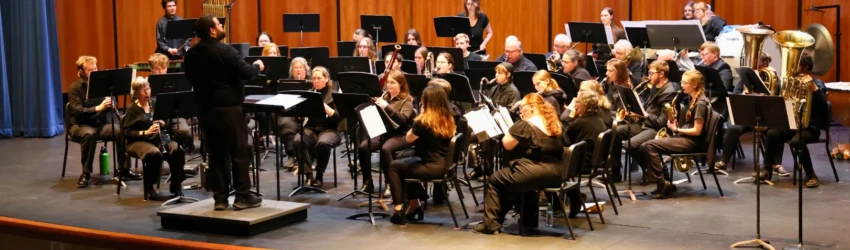 LSSU Concert Band on stage in all black. The first few rows are visible and empty, as this was a dress rehearsal.