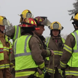 Group of fire science students speak with leadership in full uniform during simulation.