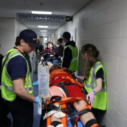 EMS students bring actors into Superior Simulation Center for medical treatment portion of the simulation.
