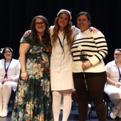 Pinning recipient and supporters on stage during ceremony.
