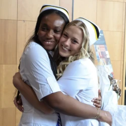 Two graduates hug following official pinning ceremony.