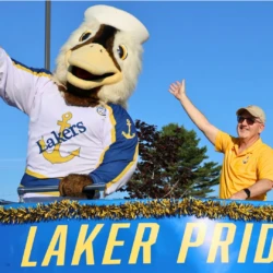 LSSU Float with Mascot and President waving above the text 'Laker Pride'